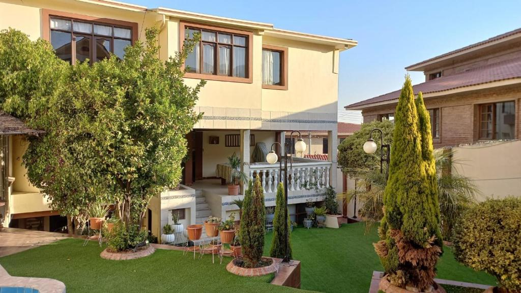 a house with a yard with trees in front of it at A&A apartamento in Cochabamba