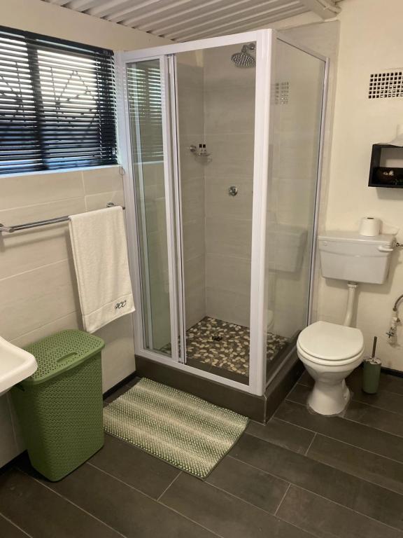 a bathroom with a shower and a toilet at Pretoria Country Club - Old Tree Hut in Pretoria