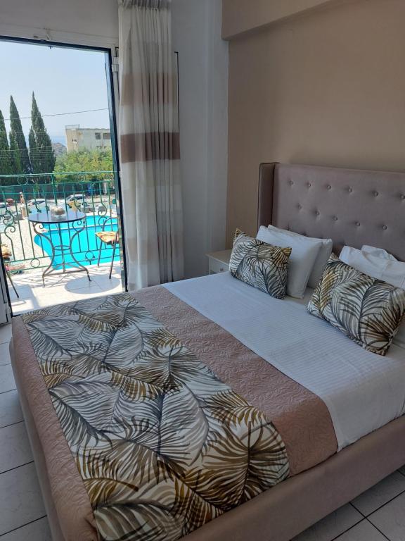 a bedroom with a large bed with a balcony at Maria Studios in Paleokastritsa