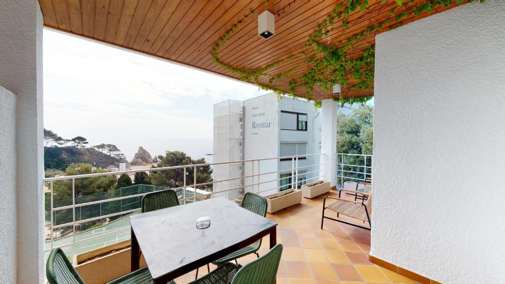 - Balcón con mesa y sillas en un edificio en Villa Reymar - diseño y vistas al mar, en Tossa de Mar
