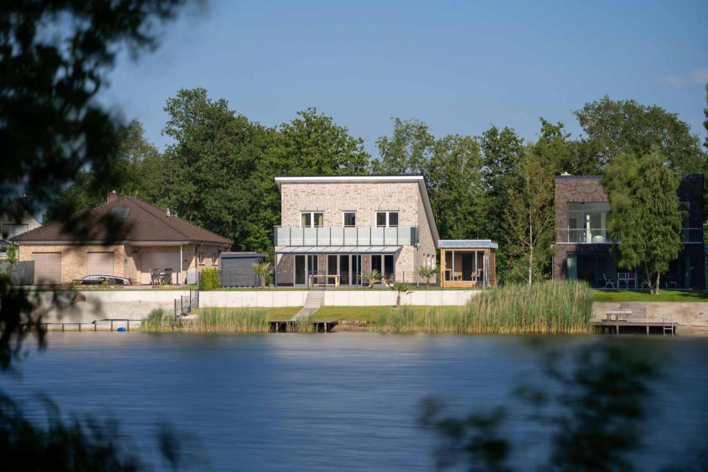 ein Haus am Ufer eines Sees in der Unterkunft Seevilla am See mit Sauna, Kamin, privatem Steg und Seezugang in Barßel