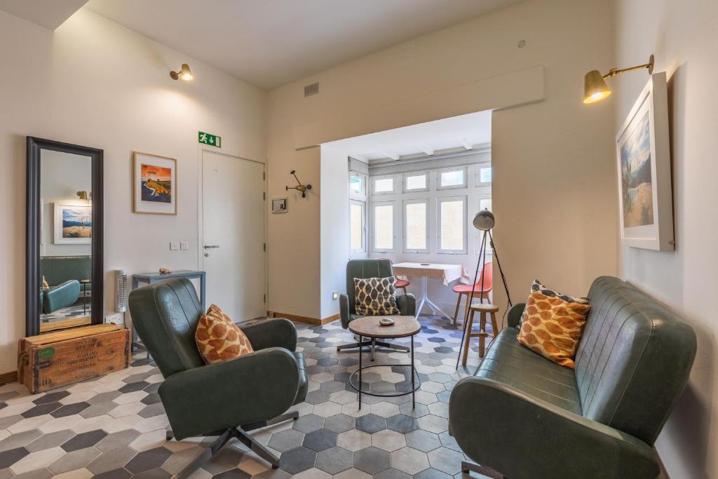 a living room with chairs and a table at Valletta Two Bedroom Apartment Close To The Sea in Valletta