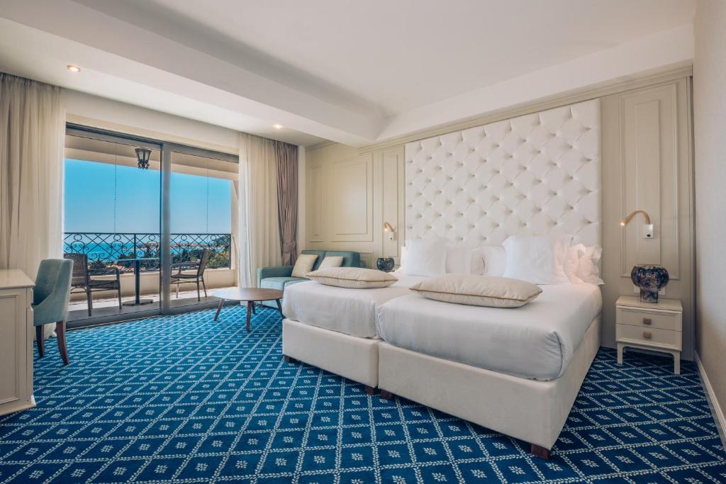a hotel room with a bed and a balcony at Iberostar Waves Slavija in Budva