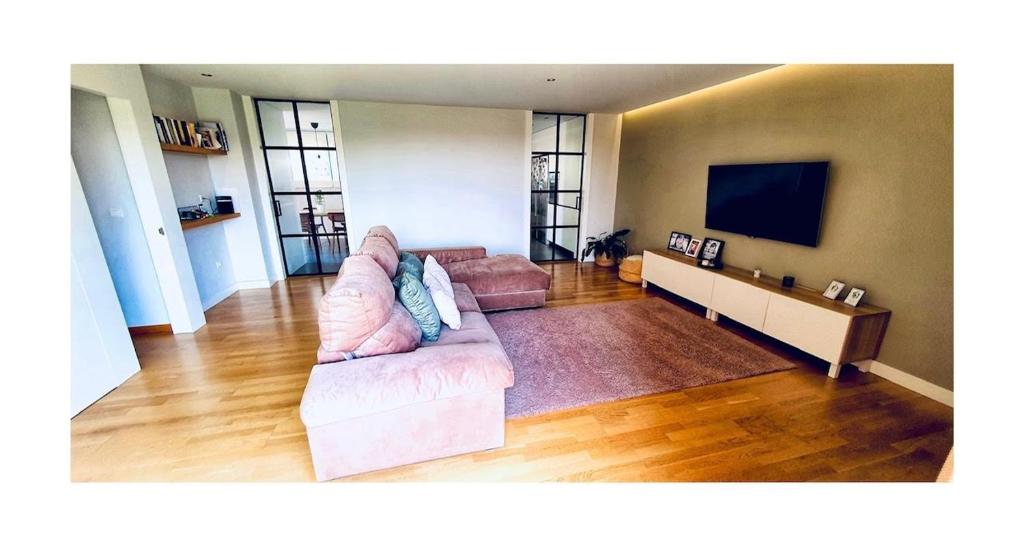 a living room with a couch and a flat screen tv at Lovely penthouse condo with pool in Valencia