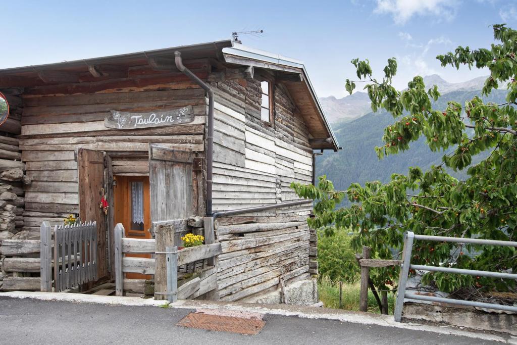 an old log cabin with a sign on it at Taulain Gotrosio in Valdisotto