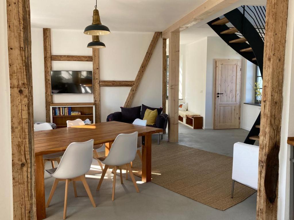 comedor con mesa de madera y sillas blancas en NEUES GESINDEHAUS (Rittergut Oelzschau b. Leipzig), en Rötha