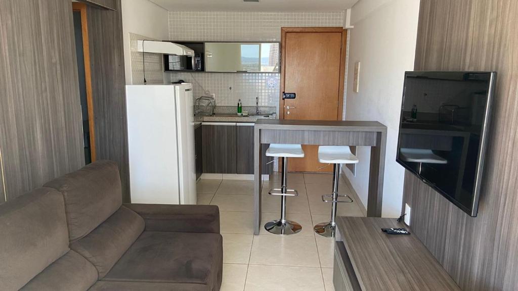 a living room with a couch and a kitchen at Flat Brookfield Towers 2414 in Goiânia
