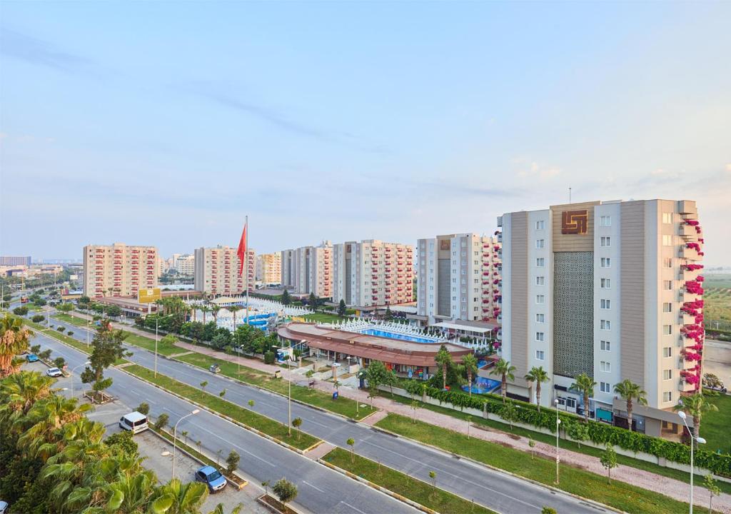 a city with tall buildings and a street with cars at Grand Park Lara Hotel in Lara