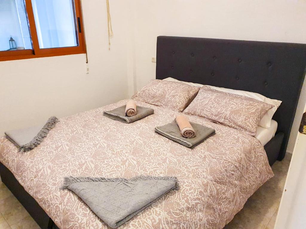 ein Bett mit einem Paar Pantoffeln darüber in der Unterkunft EL PATIO - apartment LA LUBICA in Denia