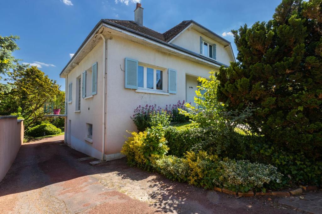 Casa blanca con ventanas y arbustos azules en Villa Palmera, en Saint-Aignan