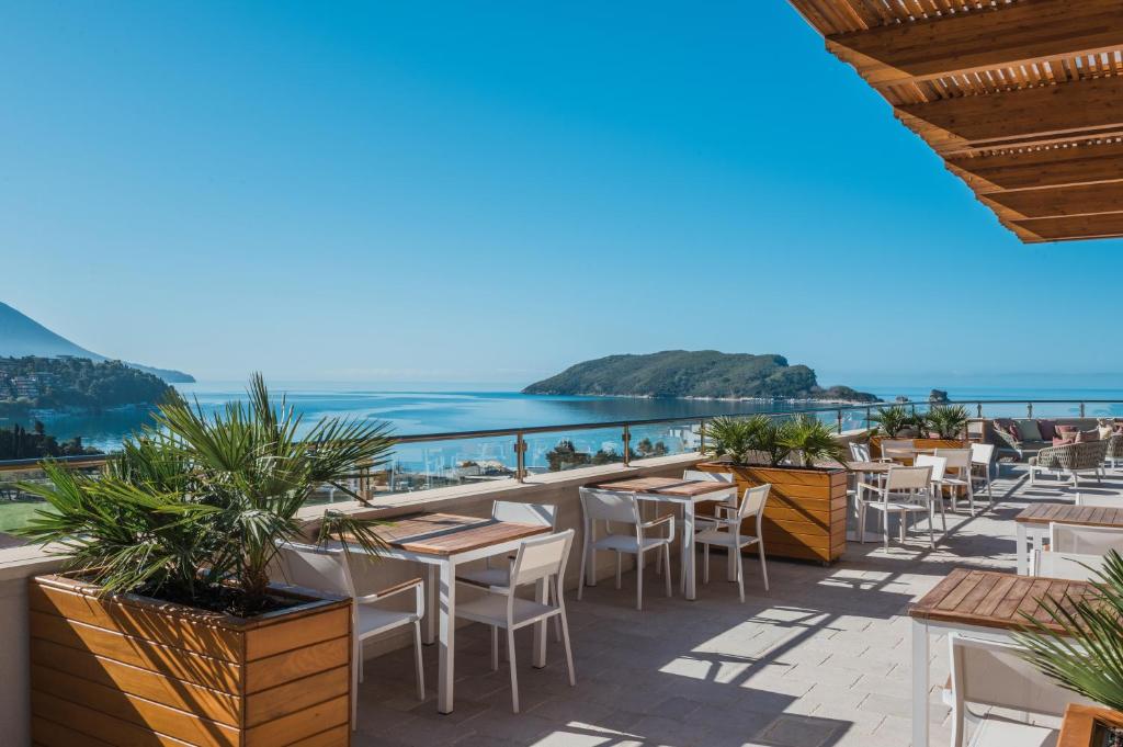 a view of the ocean from a restaurant with tables and chairs at Iberostar Waves Slavija in Budva