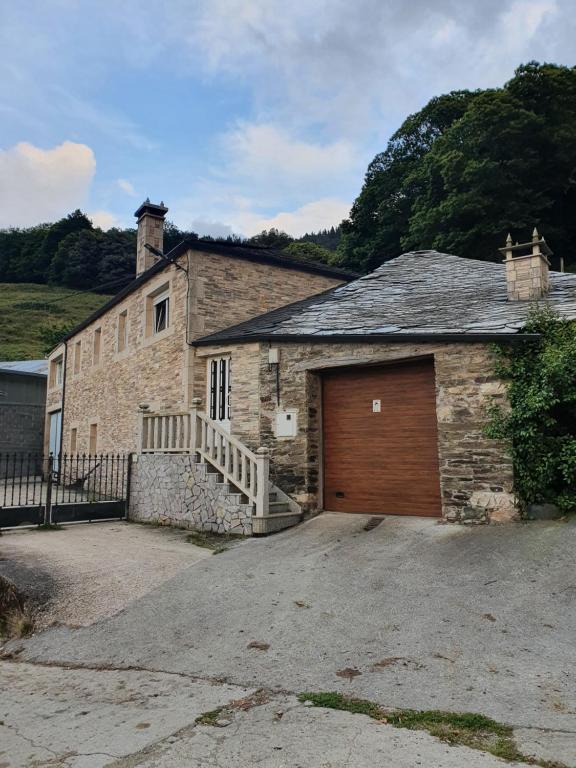 um edifício de tijolos com uma garagem com uma porta de madeira em Casa Regueirín em Lugo