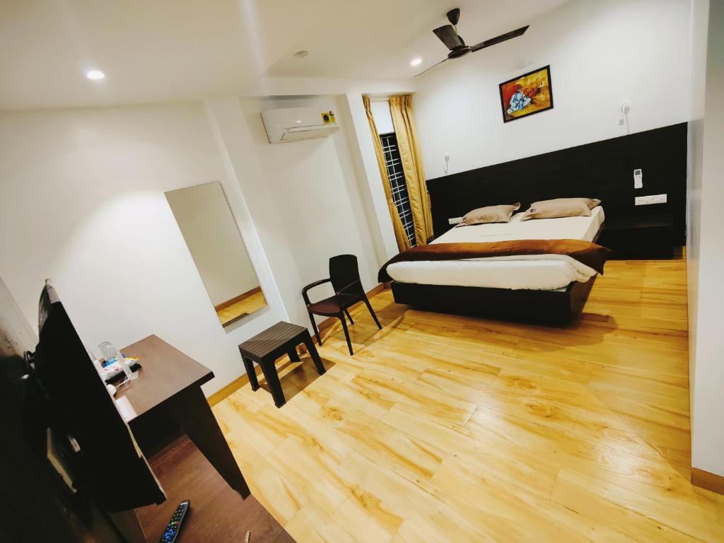Schlafzimmer mit einem Bett, einem Schreibtisch und einem Tisch in der Unterkunft Shivanand Residency in Jejūri