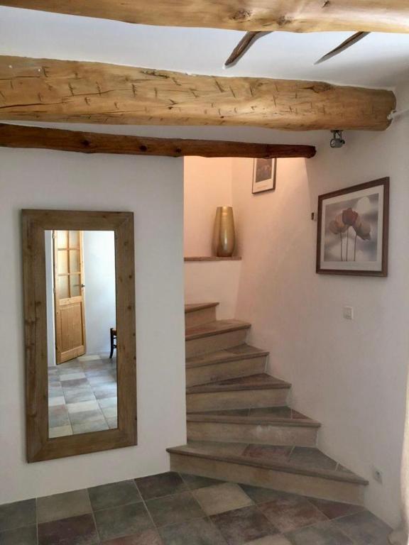 un escalier dans une maison avec un miroir et une sortie d'escalier dans l'établissement La Maison de Lily, cosy dans le Vieux-Hyères, parking gratuit, à Hyères