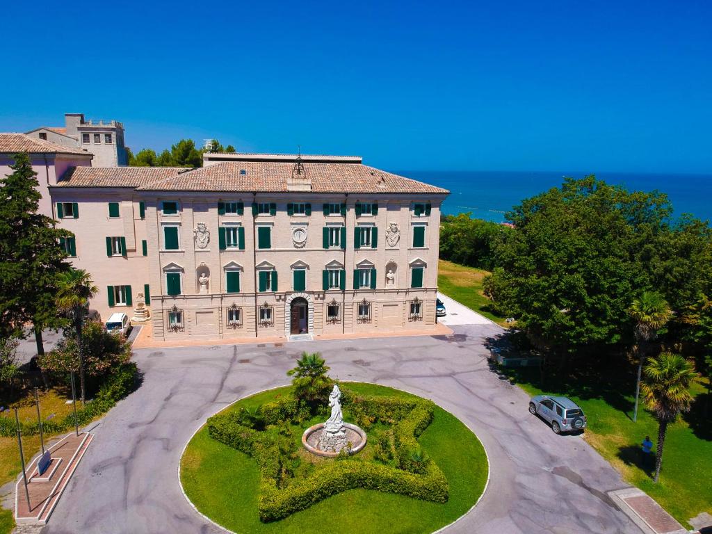 einen Luftblick auf ein großes weißes Gebäude mit einem Brunnen in der Unterkunft Domus Stella Maris - Casa per Ferie in Ancona