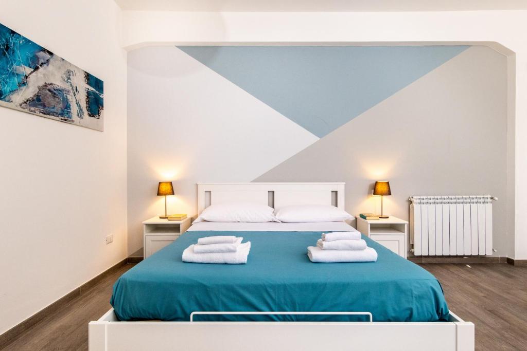 1 dormitorio con 1 cama con toallas en Blue Apartment Messina, en Messina