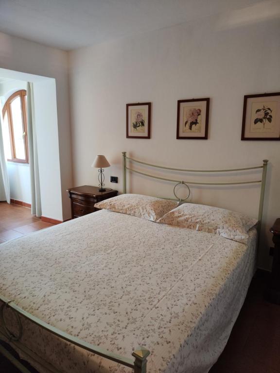 een slaapkamer met een bed en twee foto's aan de muur bij La Casa del Sole in Fresonara
