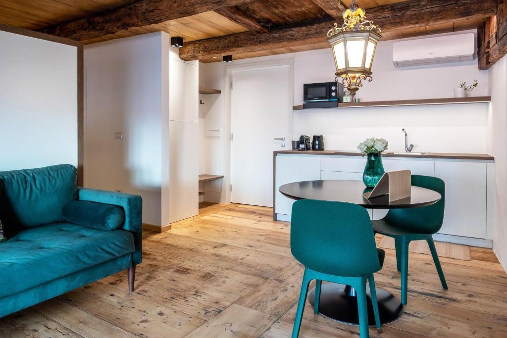 een woonkamer met een groene bank en een tafel bij Boznerhütte - La Baita Bolzano in Bolzano