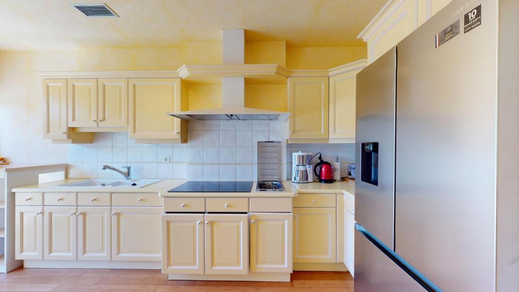 a kitchen with white cabinets and a sink at Villa Amare Granville in Saint-Pair-sur-Mer