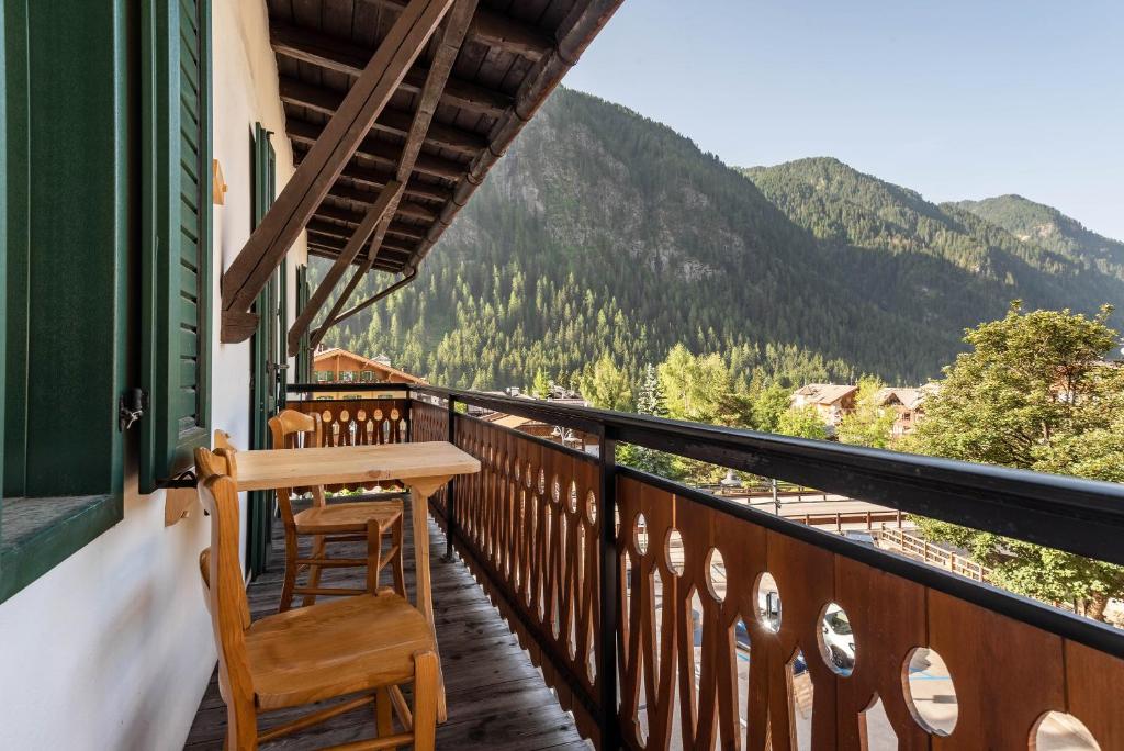 a balcony with a table and chairs and mountains at Rodella A Parte in Campitello di Fassa