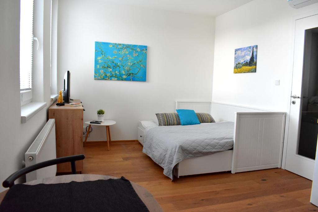 um quarto branco com uma cama e uma mesa em Airstay Prague apartment: Grebovka em Praga