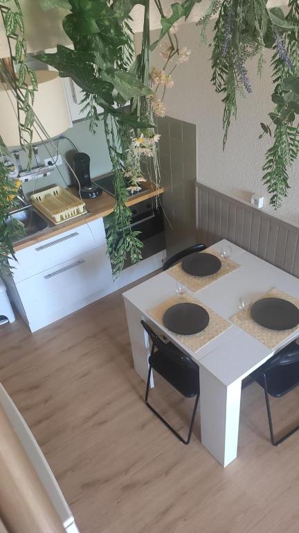 a room with a table and chairs and plants on the ceiling at Le hameau des 4 saisons 5 personnes in Bolquere Pyrenees 2000