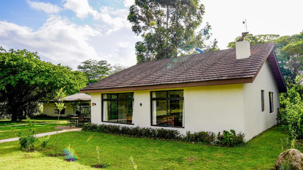 Biały dom z czarnym dachem w obiekcie Black Wattle House w mieście Nakuru