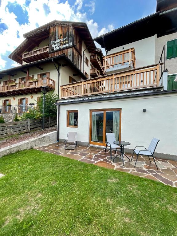 a patio with chairs and a table in front of a building at Casa Fabiolin in Daiano