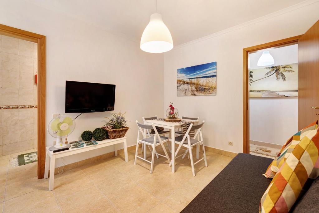 a living room with a table and a tv at Casa Canopa in Setúbal