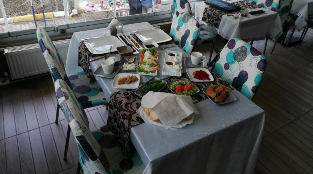 a table with plates of food on it with chairs at Yağız İndigo Blue in Şile