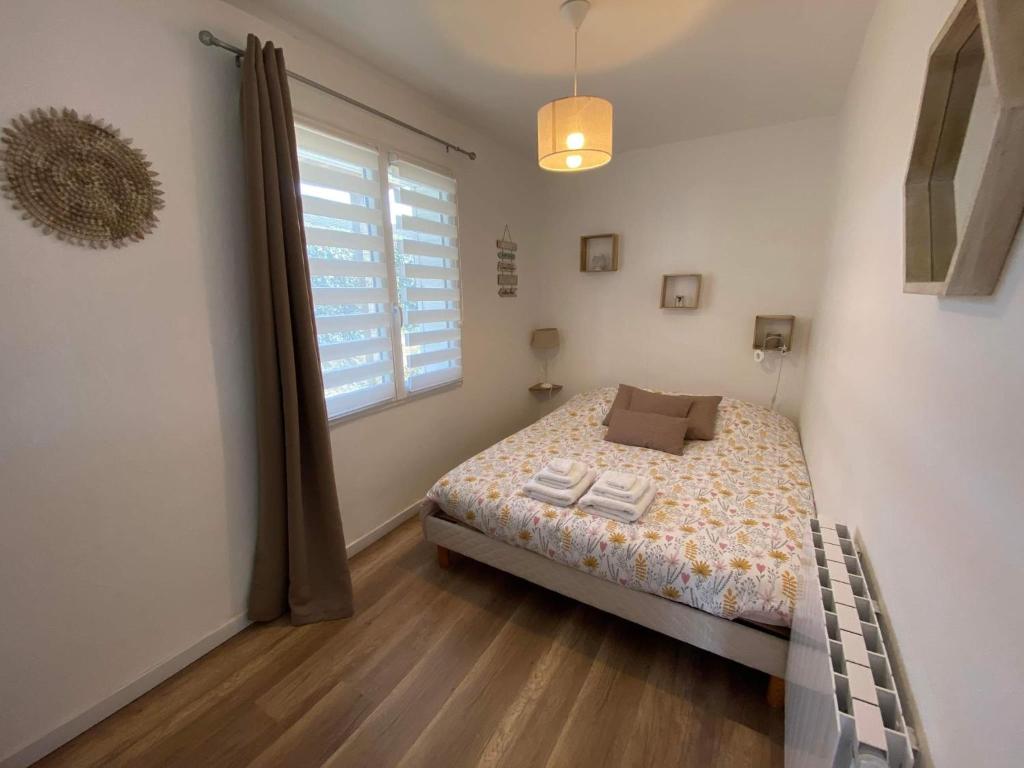 a small bedroom with a bed and a window at Entre ciel et mer, Maison neuve vue mer proche de la plage in Équihen-Plage