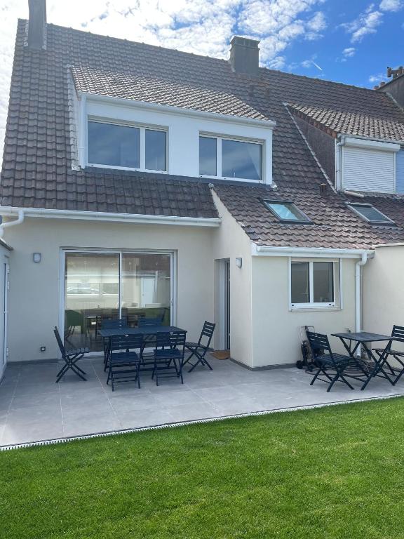 une maison avec un patio avec une table et des chaises dans l'établissement Villa Poirabelle, à Wimereux
