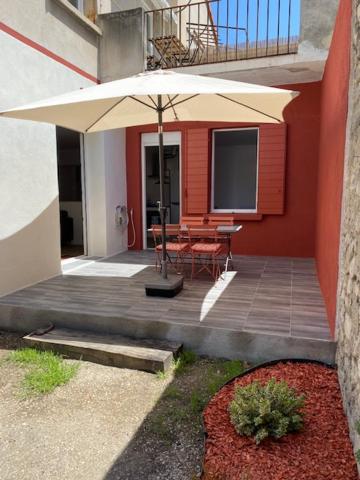 un patio avec une table et un parasol dans l'établissement Lumineux extérieur proche gare et stationnement privé, à Avignon