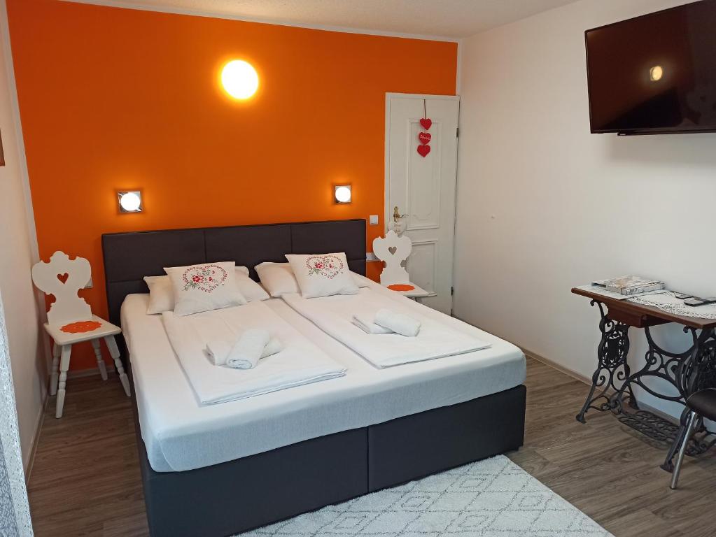 a bedroom with a bed with an orange wall at Apartma Golob in Zgornja Kungota