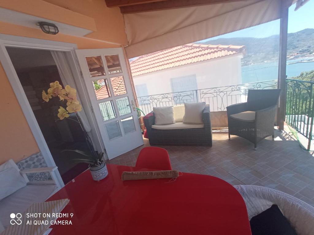 a living room with a red table and chairs on a balcony at Seminas House in Skopelos Town