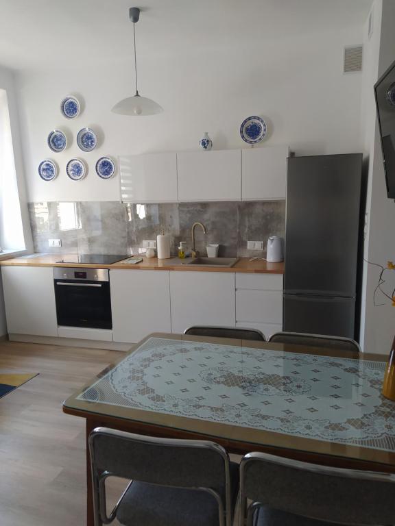 Una cocina con una mesa y algunos platos azules en la pared. en Apartament Centrum u Marianny, en Częstochowa