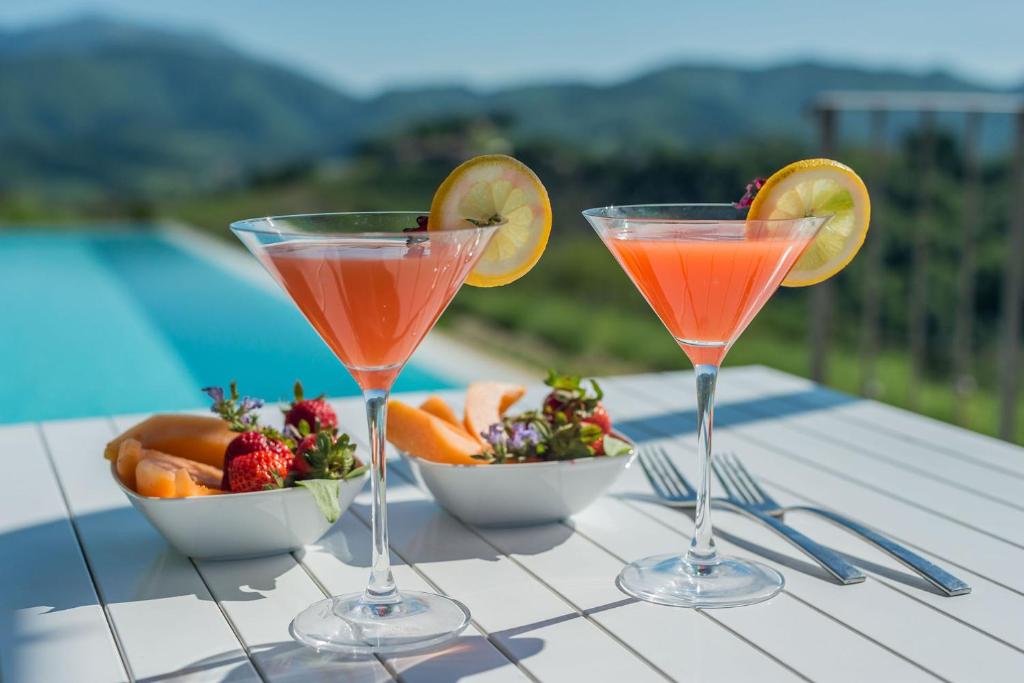 drie cocktails en een fruitschaal op een tafel bij Villa del Duca in Urbania