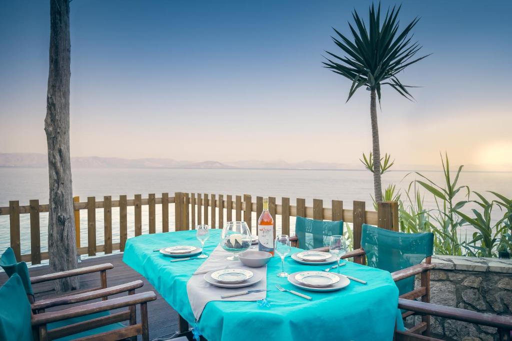 a table with a blue table cloth and chairs and the ocean at Ionian Grand in Kornáta