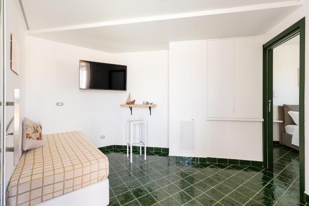 a bedroom with white walls and green tile flooring at Don Leonardo - pool and wellness in Polignano a Mare
