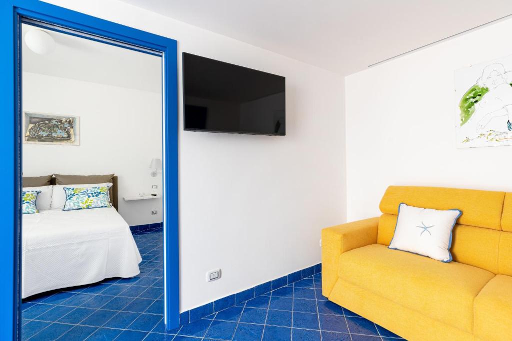 a living room with a yellow couch and a bed at Don Leonardo - pool and wellness in Polignano a Mare