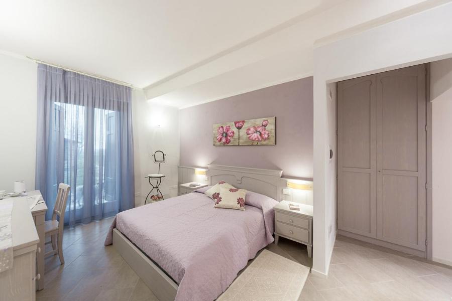 a bedroom with a bed and a desk and a window at B&B CORTE SAN MICHELE Desenzano in San Martino della Battaglia