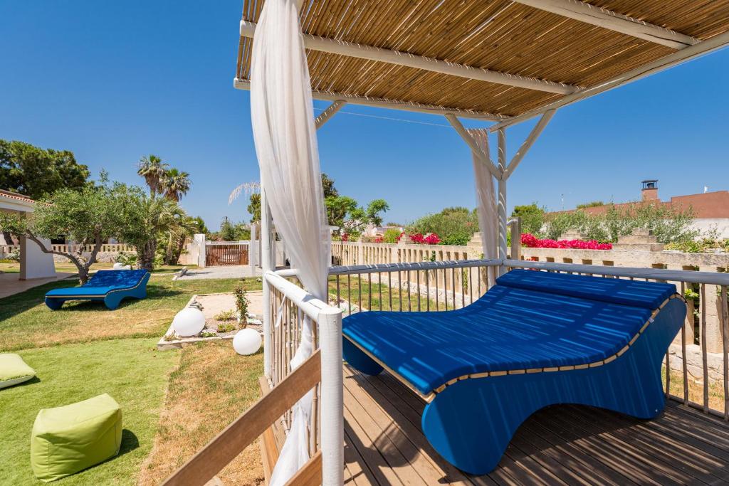 a pergola with a blue bed on a deck at Don Leonardo - pool and wellness in Polignano a Mare