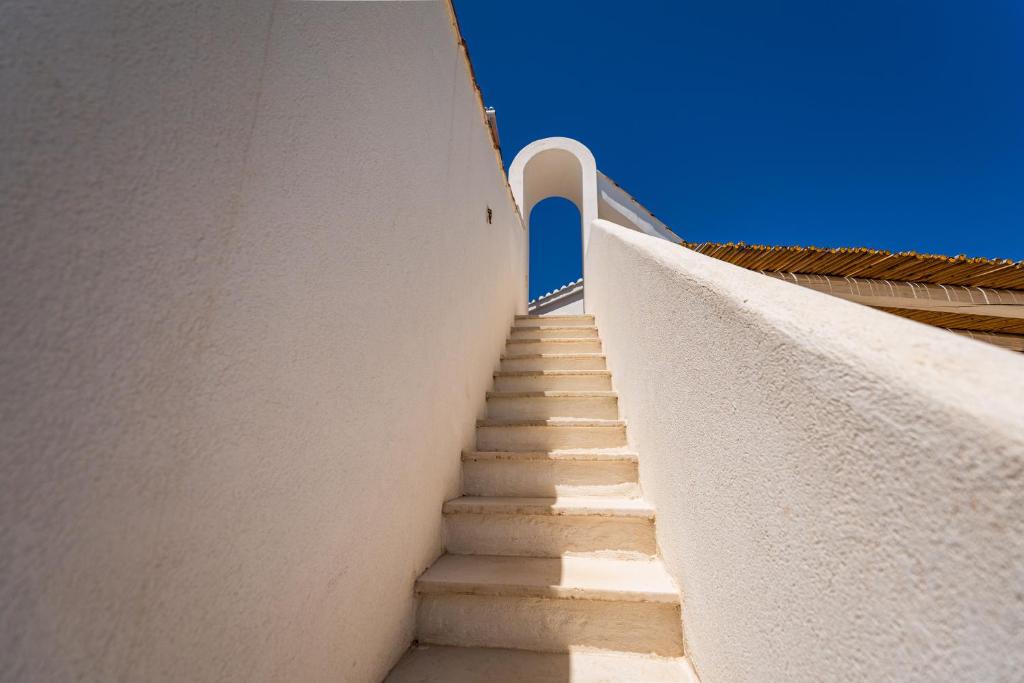 a staircase leading up to a building with a blue door at Don Leonardo - pool and wellness in Polignano a Mare