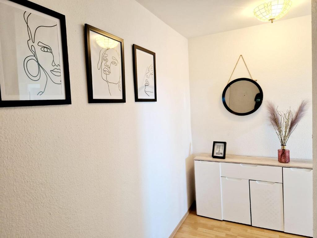 um quarto com três fotografias na parede e um espelho em Relax Wohnung in Bensheim Auerbach em Bensheim