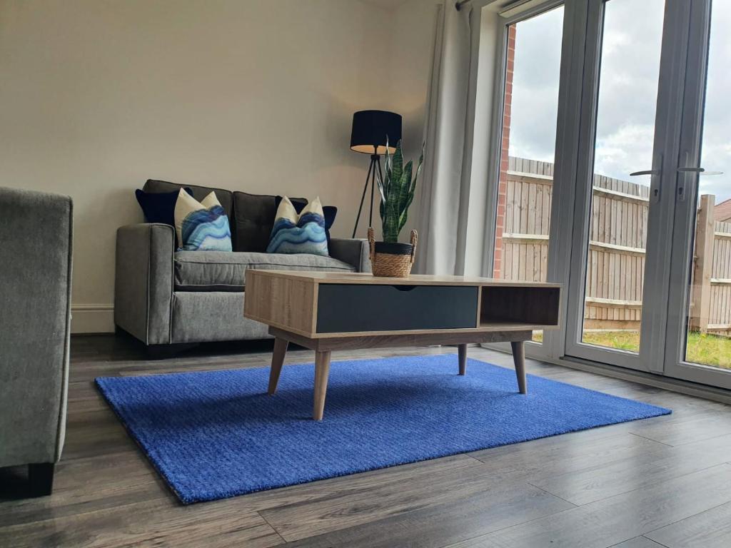 uma sala de estar com um sofá e uma mesa de centro em Cheerful 4 - Tranquil Oasis Modern and Spacious Retreat 4-Bedroom with Private Parking and Serene Gardens em Luton