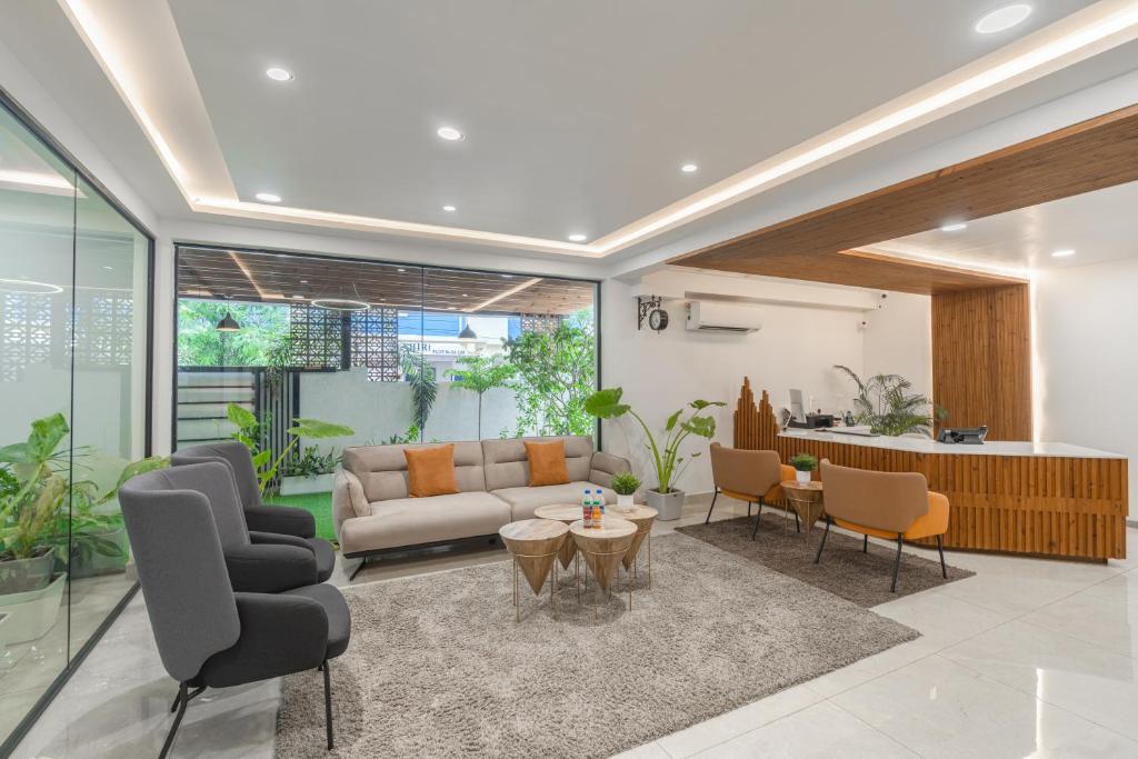 Una sala de estar con un sofá y sillas y una mesa. en Hotel Akoya - HITECH City Hyderabad, en Hyderabad