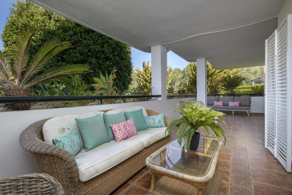 a patio with a couch and a glass table at Balcon de Puente Romano in Marbella