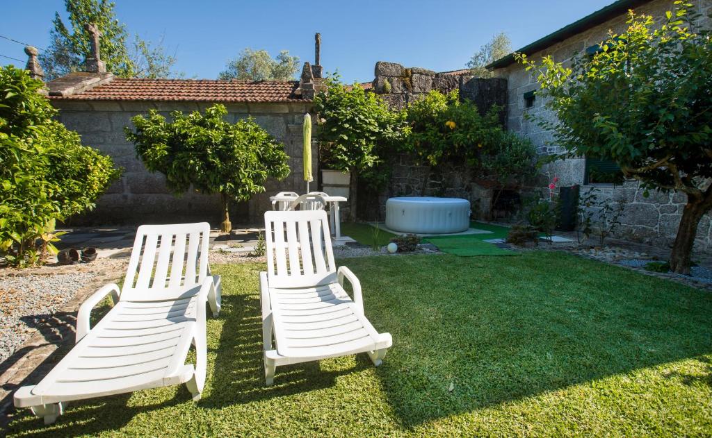 twee witte stoelen op het gras in een tuin bij Casa Pereira in Balança