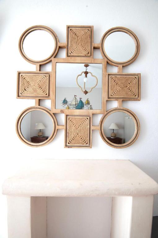 a group of mirrors on a wall above a white table at Astrio Suites in Livadi