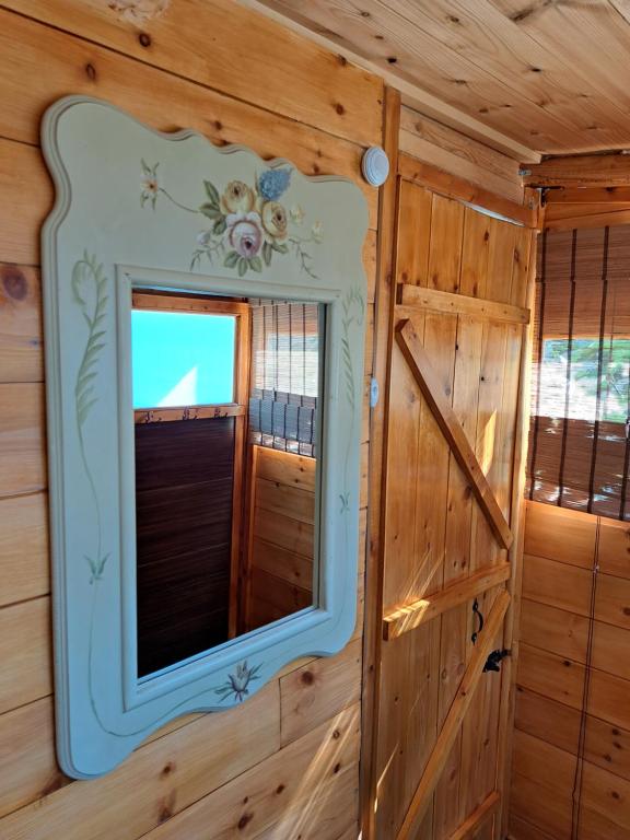 a mirror on the wall of a wooden cabin at Wooden House at the Mountain-private in Paránimfoi